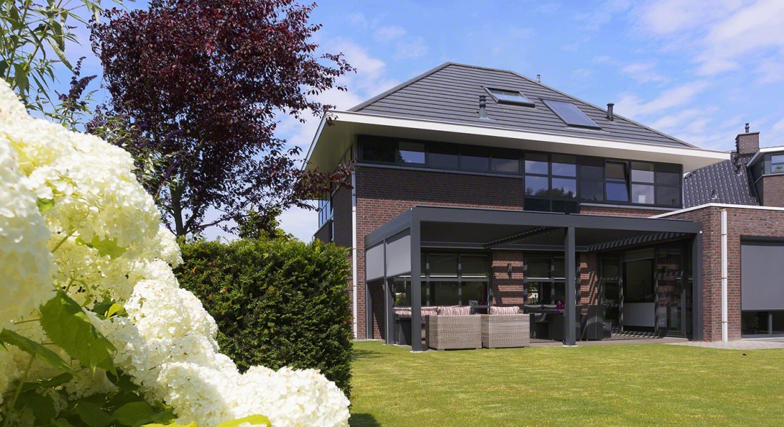 Sfeervol terras met een zonwerend lamellendak