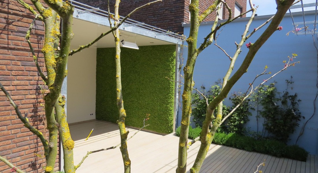 Een sfeervol groen terras met moswanden
