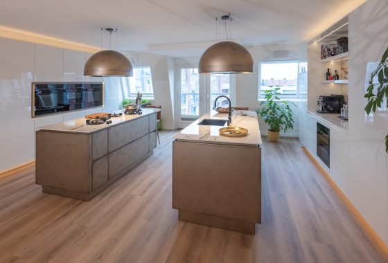 Luxe leefkeuken met dubbel eiland en bronzen accenten