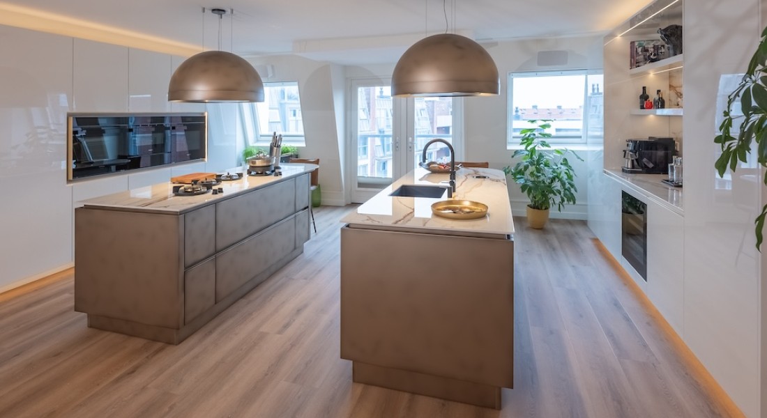 Luxe leefkeuken met dubbel eiland en bronzen accenten