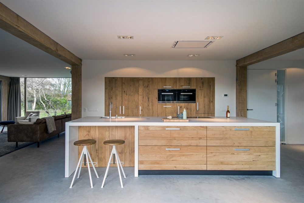 Houten woonkeuken met kookeiland van wit silestone werkblad en ontbijtbar via JP Walker #keuken #kookeiland #houtenkeuken