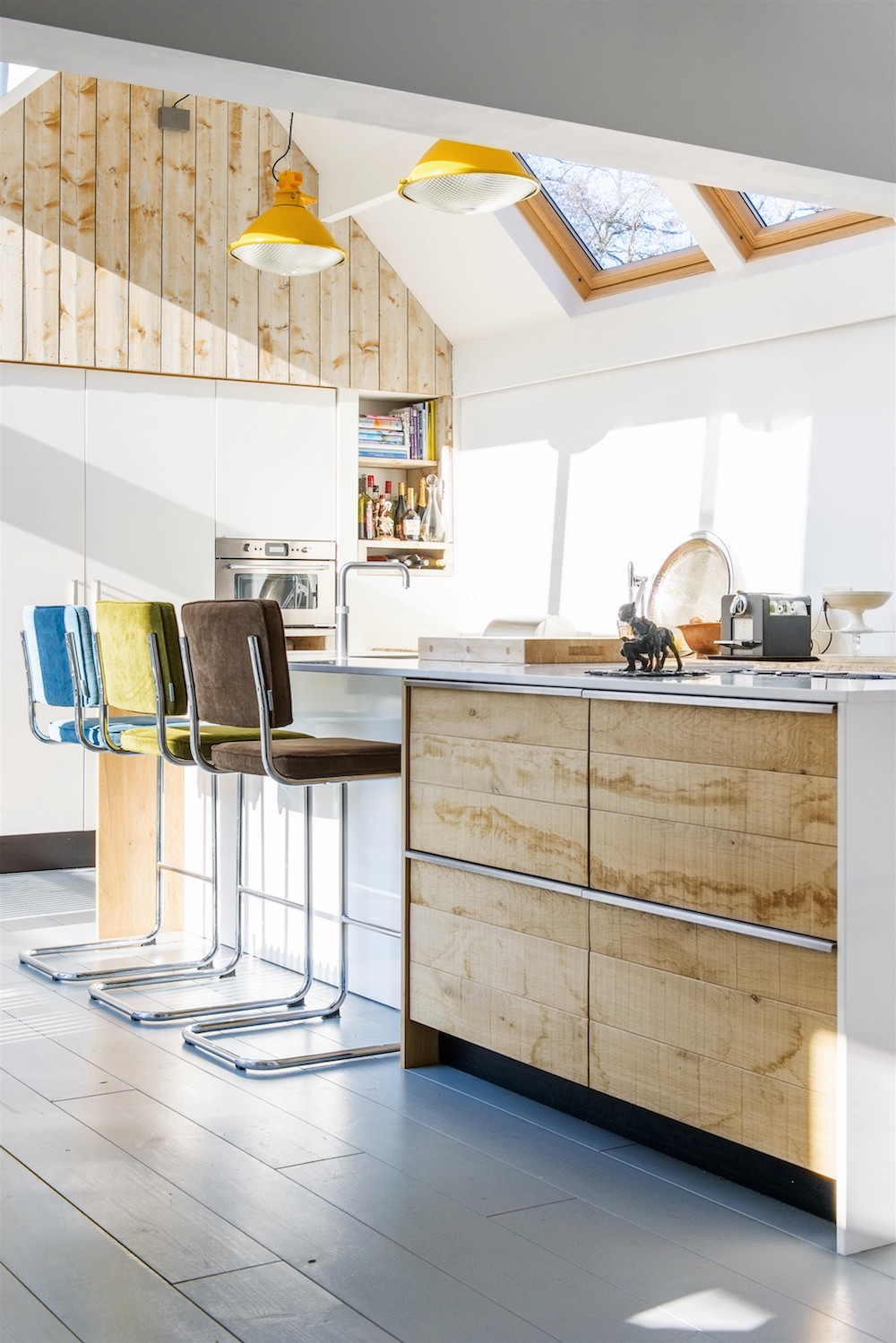 Minimalistische gezelligheid gecombineerd met stoer hout. Het ruwe eiken van de fronten komt mooi terug in de rest van de keuken en de hoge wand. Op deze manier ingedeeld is er in de relatief kleine keuken van JP Walker voldoende kastruimte.