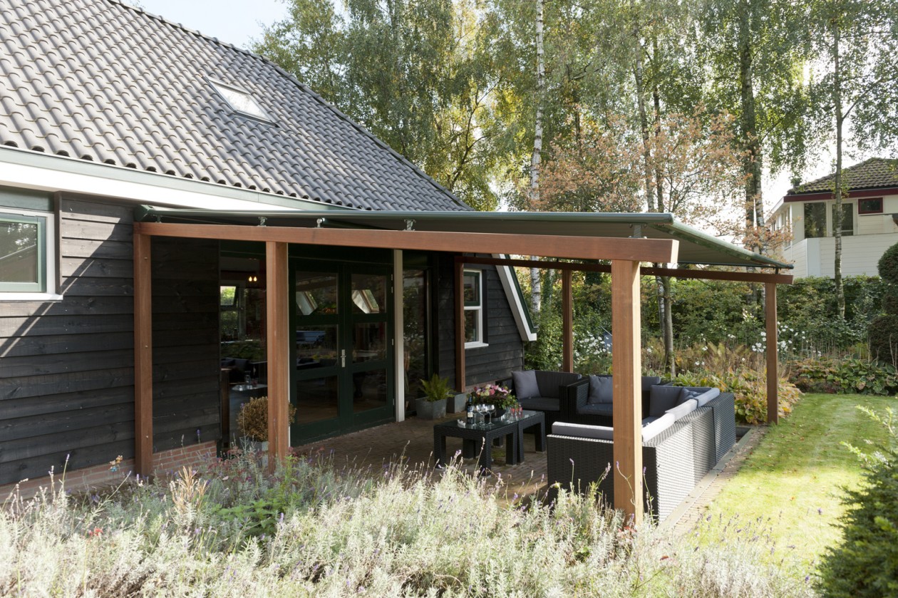 Tuin met houten terrasoverkapping met zonwerend en waterdicht doek via Jumbo